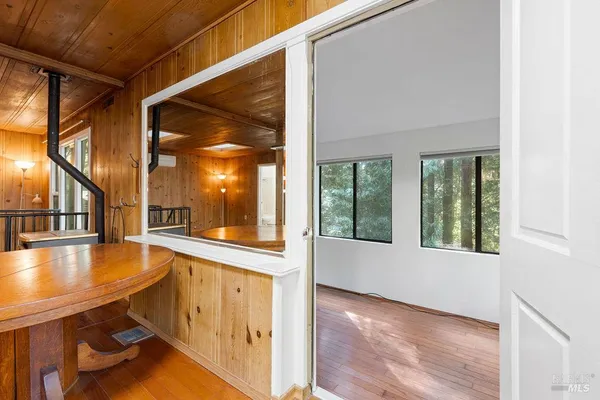 a view of a room with wooden floor and a ceiling fan