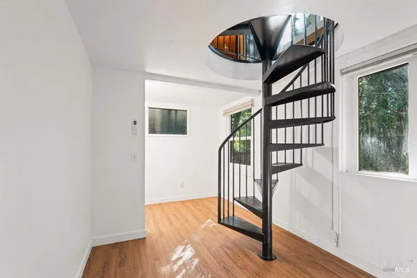a view of a hallway with wooden floor and staircase