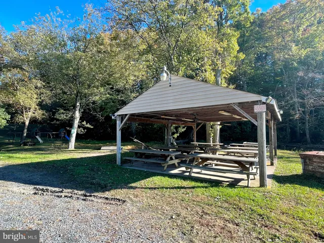 a view of swimming pool with large trees and a big yard with a small yard