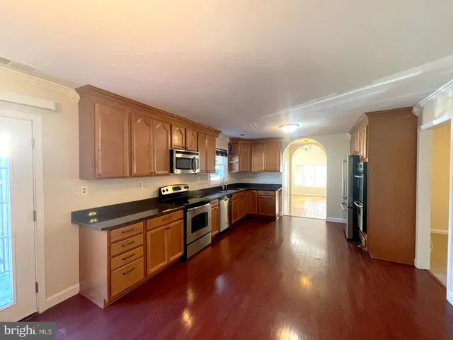 a kitchen with stainless steel appliances kitchen island wooden cabinets and granite counter tops