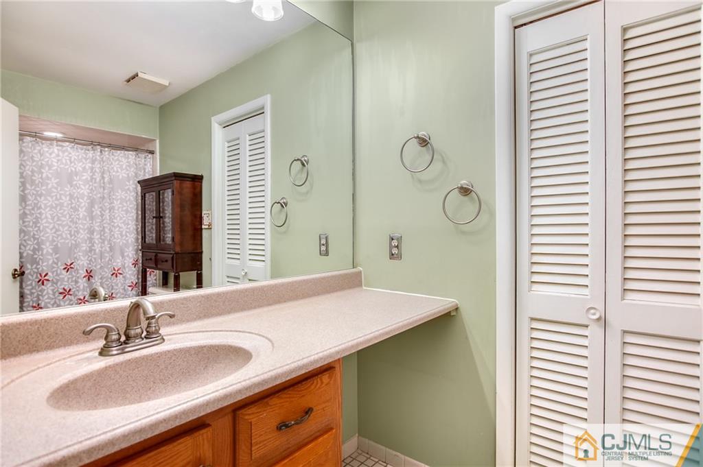 54 Holly Court Edison, NJ 08820 - Photo 12 of 25 a bathroom with a granite countertop sink and a mirror