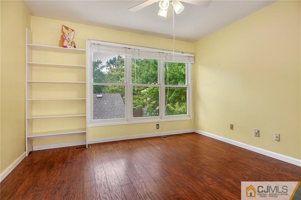 54 Holly Court Edison, NJ 08820 - Photo 14 of 25 an empty room with wooden floor and windows