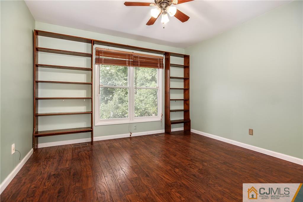 54 Holly Court Edison, NJ 08820 - Photo 16 of 25 a view of an empty room with a window and wooden floor