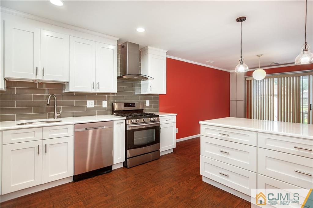 54 Holly Court Edison, NJ 08820 - Photo 3 of 25 a kitchen with stainless steel appliances granite countertop a stove a sink and white cabinets