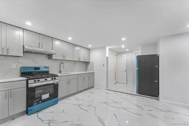 a large kitchen with a stove and a refrigerator