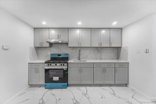 a kitchen with kitchen island granite countertop a stove a sink and a refrigerator