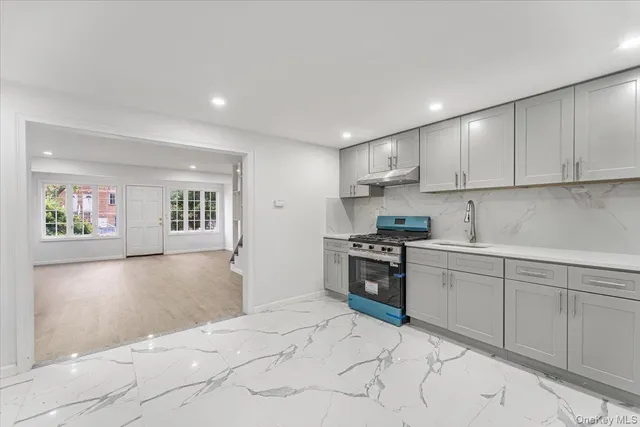 a kitchen with granite countertop a stove top oven sink and cabinets
