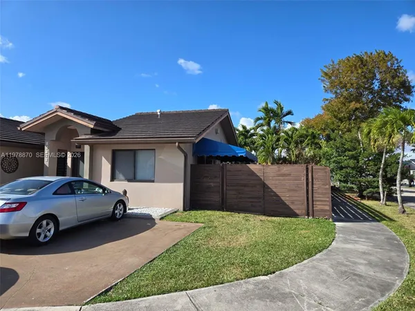 a car parked in front of house with a yard