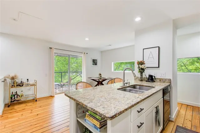 a room with kitchen island a wooden floor and large windows