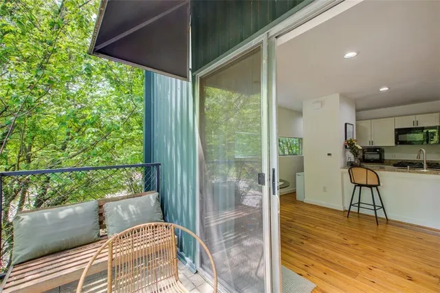 a living room with stainless steel appliances kitchen island granite countertop furniture and a wooden floor