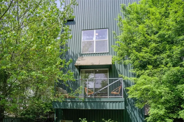 a view of a small house with a trees from a balcony