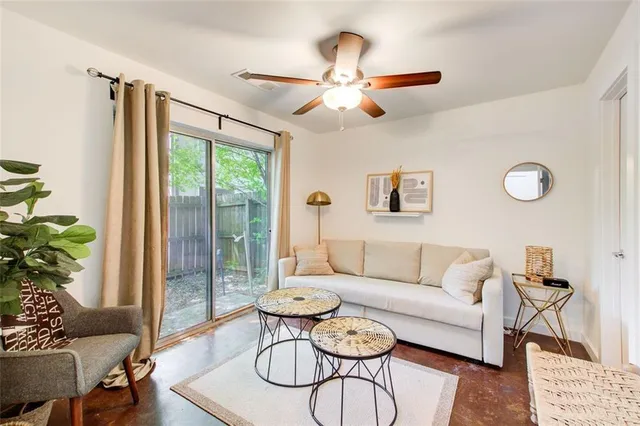 a living room with furniture ceiling fan and a window