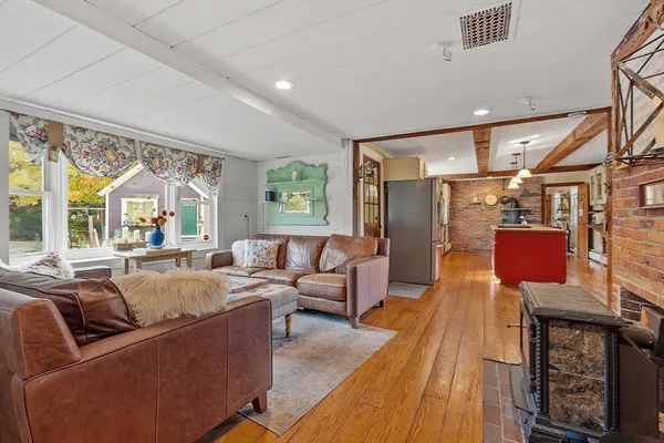 a living room with furniture fireplace and large windows
