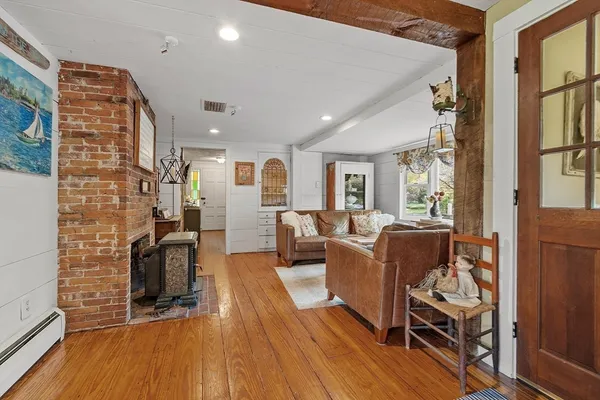 a living room with furniture a fireplace and wooden floor