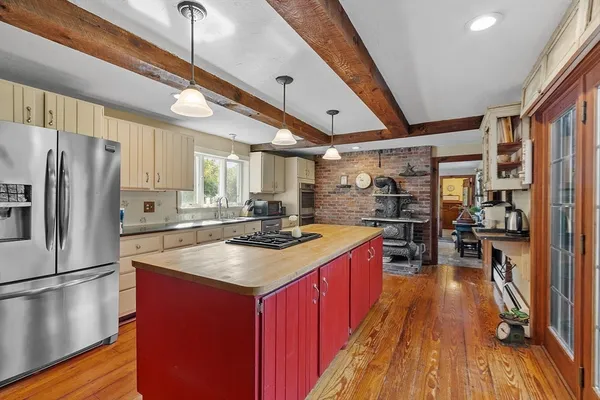 a kitchen with stainless steel appliances granite countertop a refrigerator a stove and a wooden floors