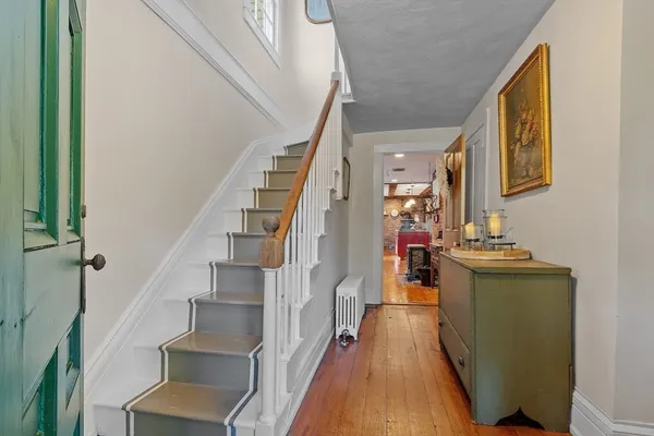 a view of a hallway with wooden floor and staircase