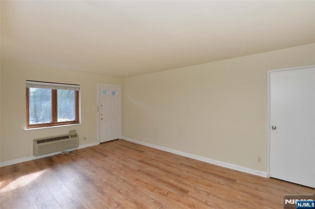 250 Oak Street, Unit E4 Ridgewood, NJ 07450 - Photo 5 of 12 an empty room with wooden floor and windows