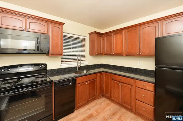 a kitchen with granite countertop stainless steel appliances and wooden cabinets