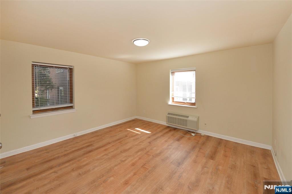 250 Oak Street, Unit E4 Ridgewood, NJ 07450 - Photo 8 of 12 a view of an empty room with wooden floor and a window