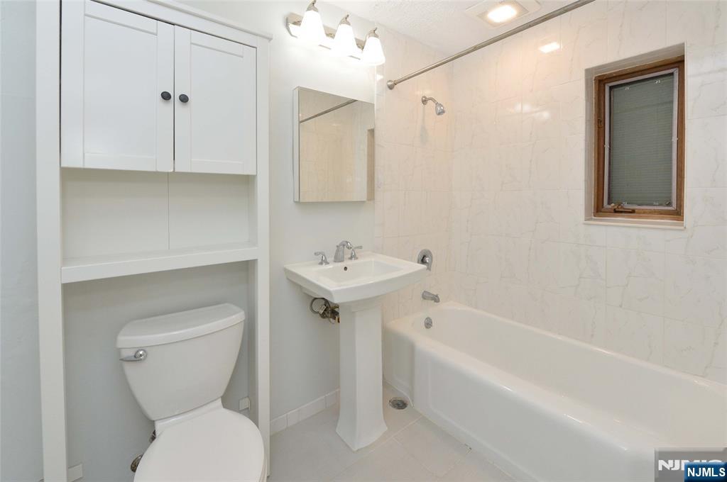250 Oak Street, Unit E4 Ridgewood, NJ 07450 - Photo 10 of 12 a bathroom with a toilet sink and bathtub