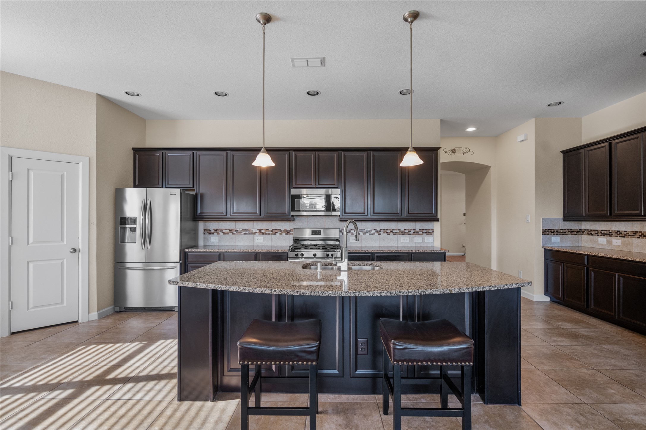 9430 Jayci Hills Lane Cypress, TX 77433 - Photo 12 of 28 a kitchen with kitchen island granite countertop a sink a center island stainless steel appliances and cabinets