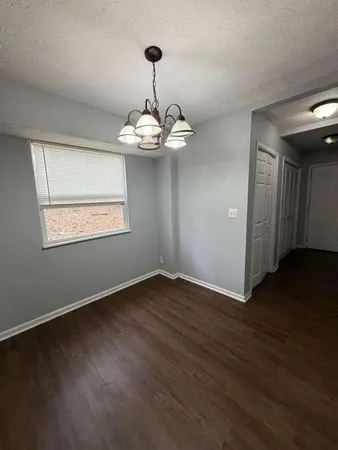 a view of wooden floor chandelier and windows in a room