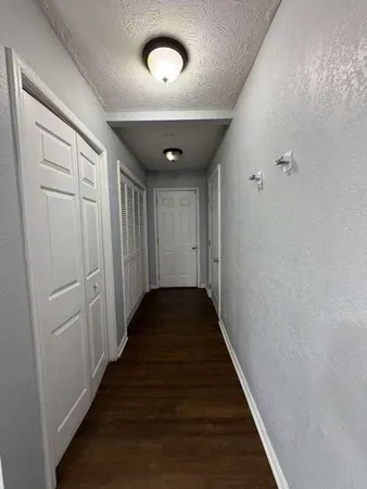a view of a hallway with wooden floor
