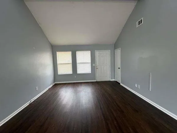 a view of an empty room and wooden floor and window
