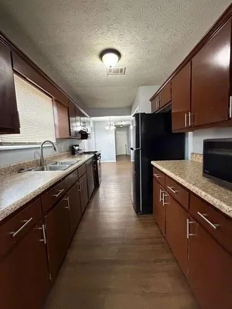 a kitchen with stainless steel appliances granite countertop a sink a stove and a refrigerator