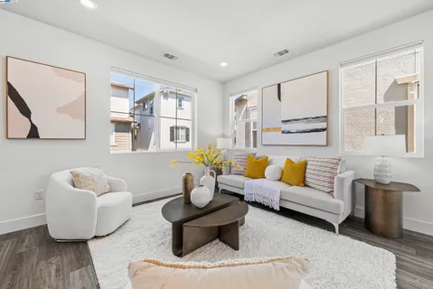 a living room with furniture white walls and kitchen view
