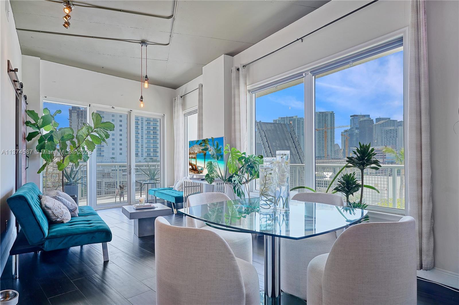 10 Southwest South River Drive, Unit 703 Miami, FL 33130 - Photo 12 of 47 a dining room with furniture a potted plant and a floor to ceiling window