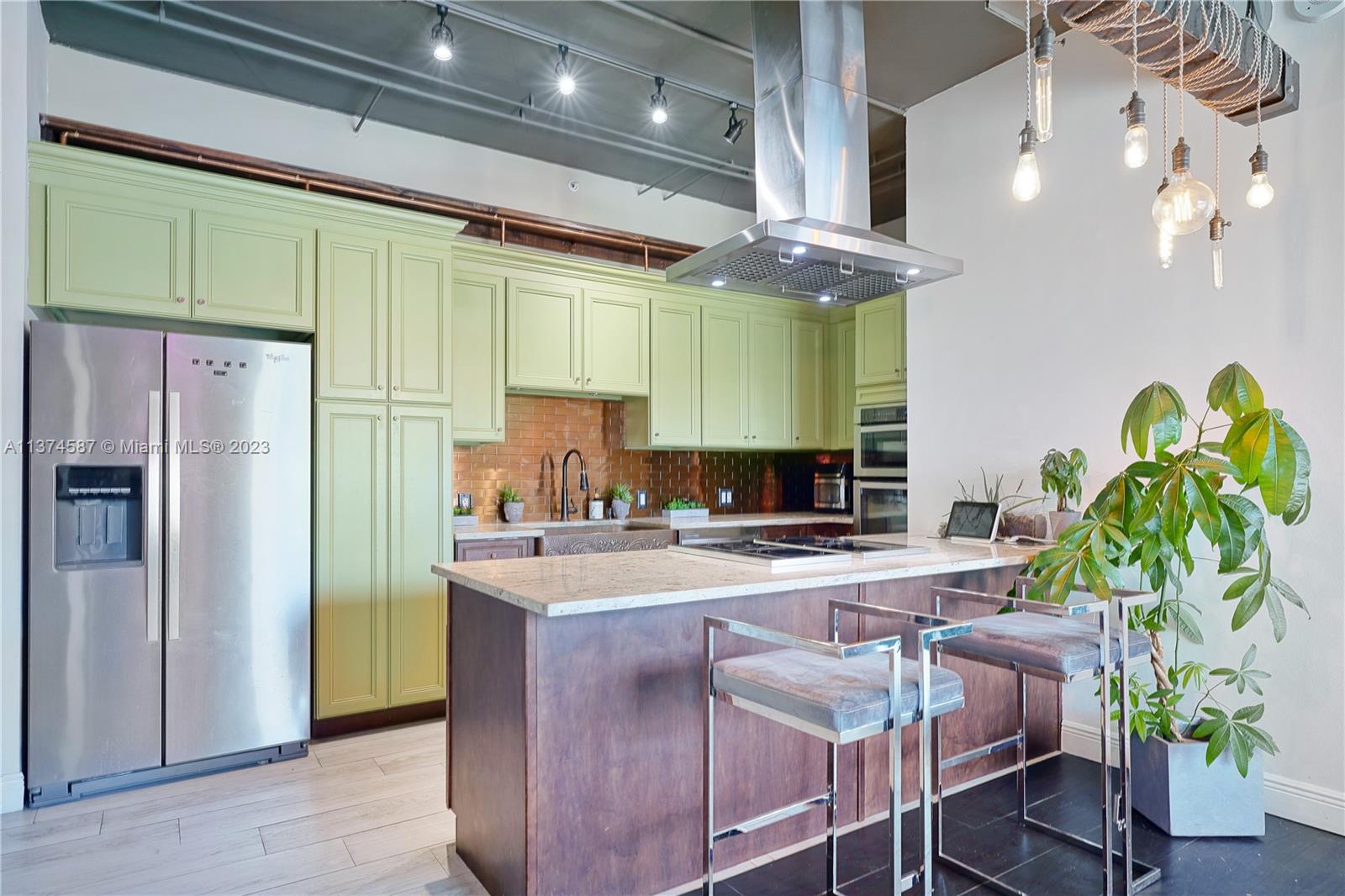10 Southwest South River Drive, Unit 703 Miami, FL 33130 - Photo 14 of 47 a kitchen with stainless steel appliances a sink a refrigerator and a counter top space
