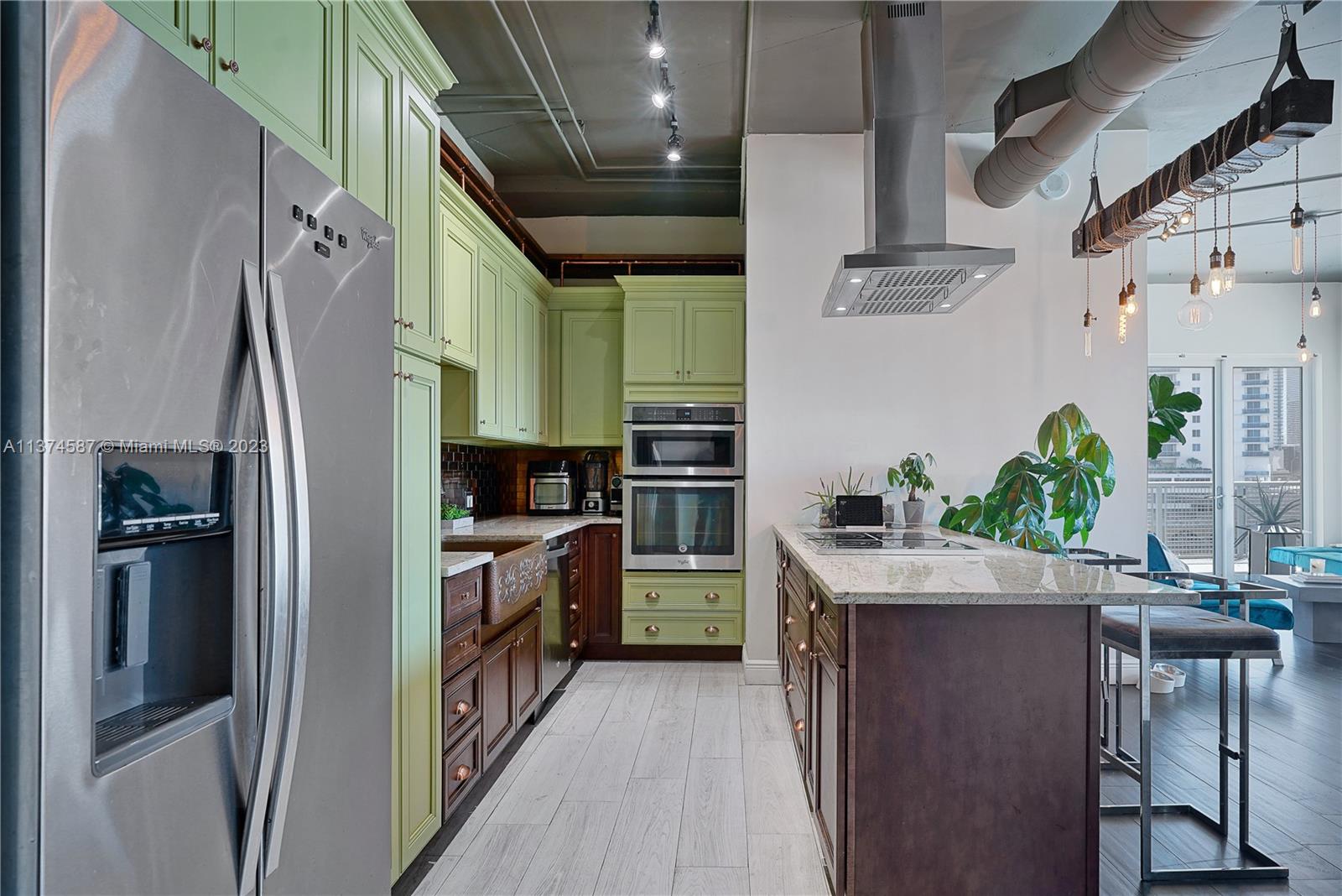 10 Southwest South River Drive, Unit 703 Miami, FL 33130 - Photo 15 of 47 a kitchen with stainless steel appliances granite countertop a refrigerator a stove and a sink