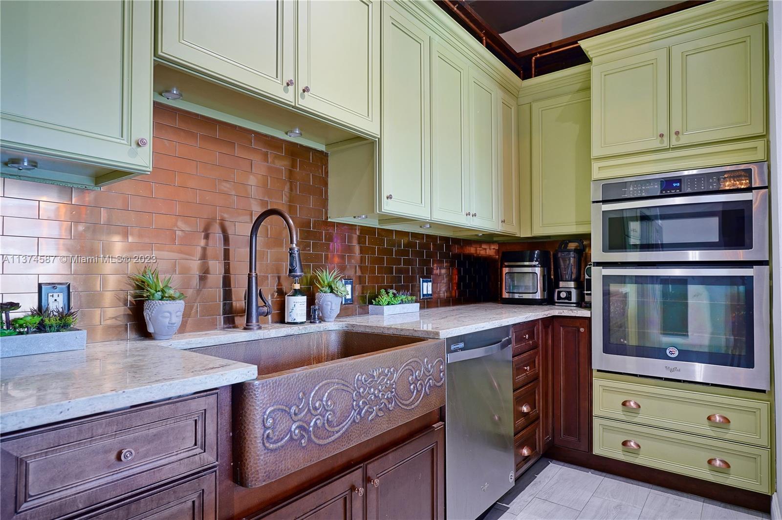 10 Southwest South River Drive, Unit 703 Miami, FL 33130 - Photo 16 of 47 a kitchen with granite countertop a sink and cabinets