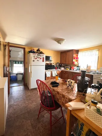 a view of a dining room with furniture and a kitchen