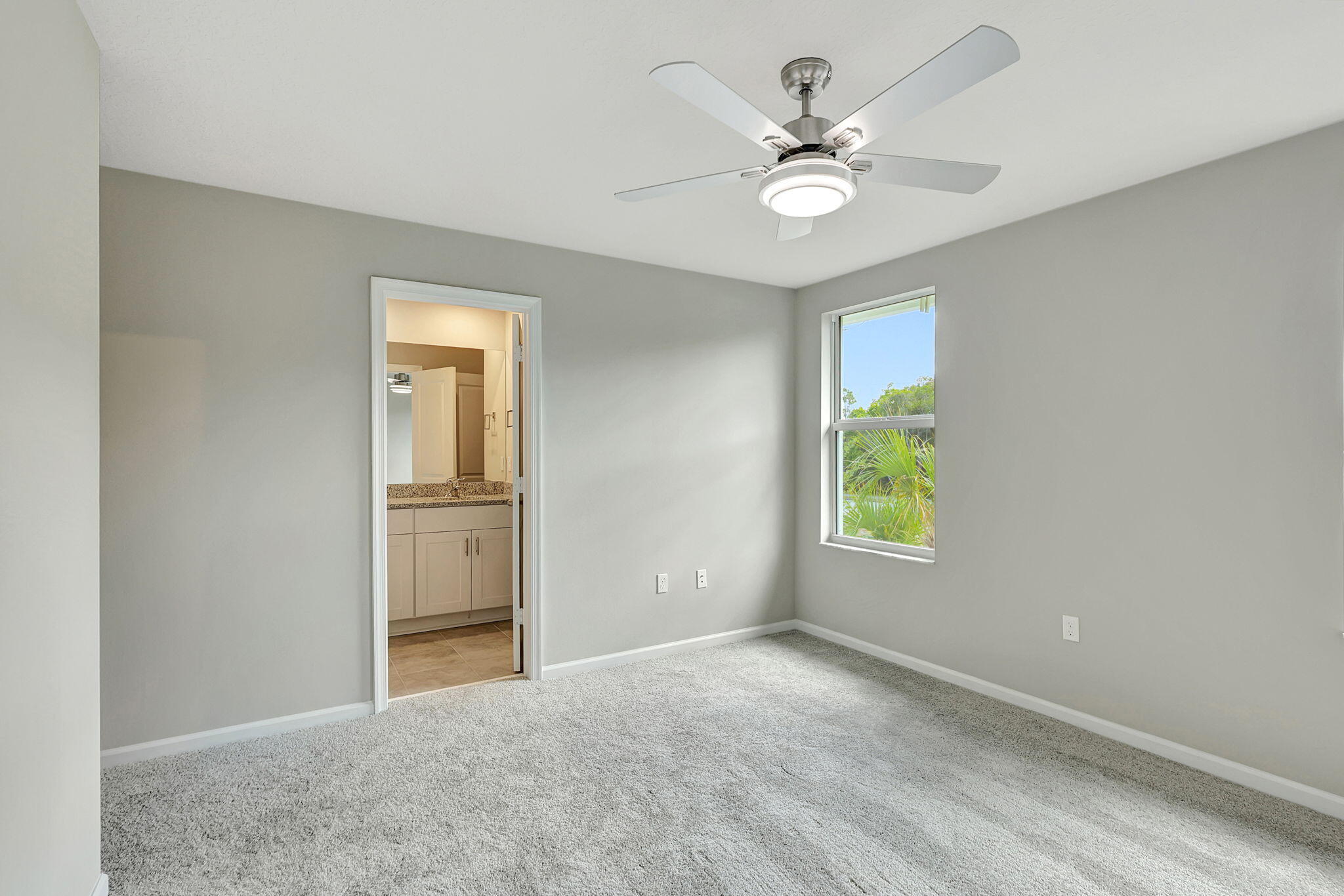 5694 Southeast Edgewater Circle Stuart, FL 34997 - Photo 13 of 22 an empty room with windows and ceiling fan