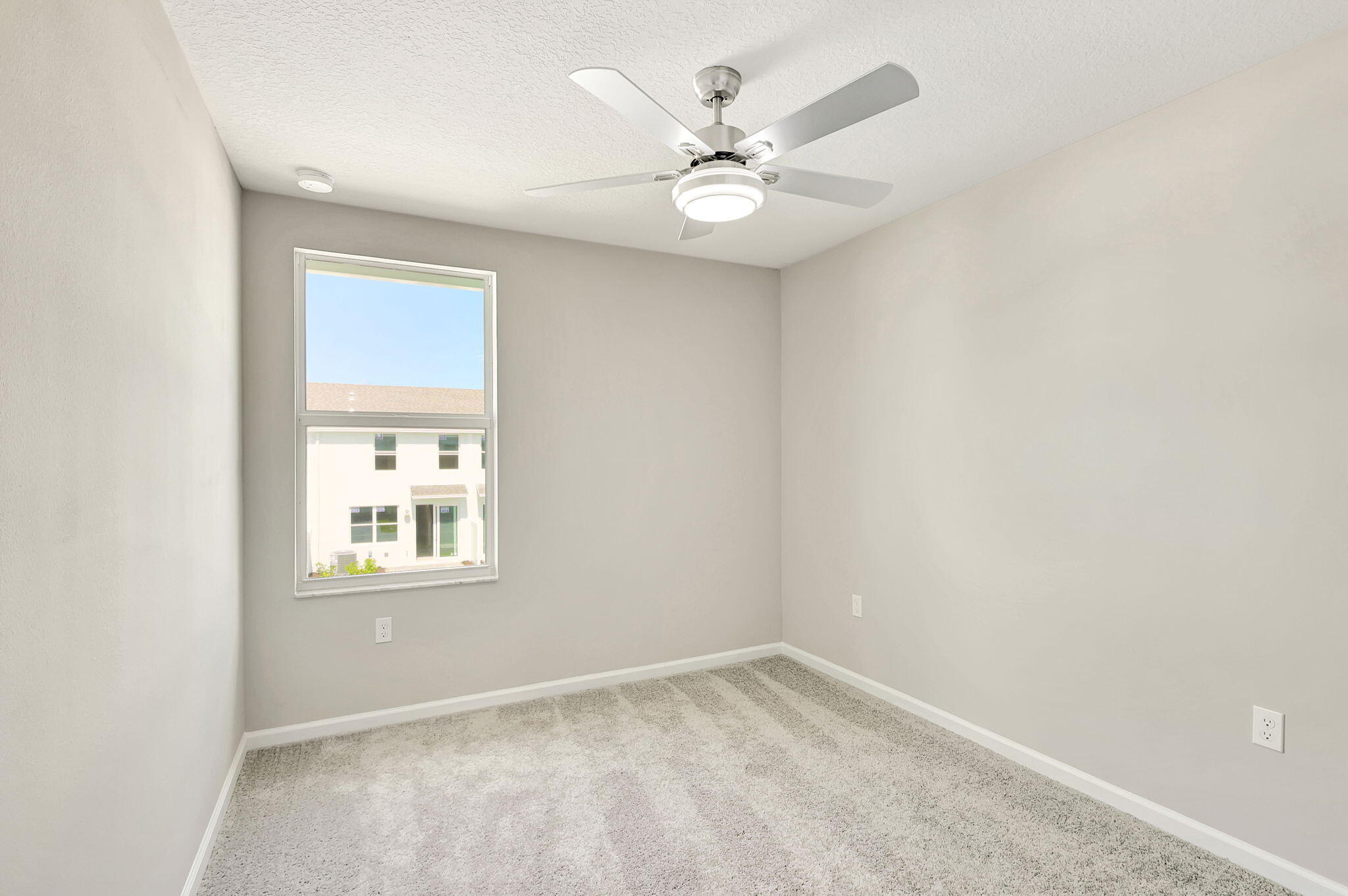 5694 Southeast Edgewater Circle Stuart, FL 34997 - Photo 16 of 22 an empty room with windows and fan