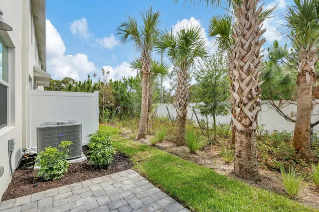a front view of a house with a yard and potted plants