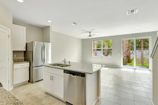 a kitchen with stainless steel appliances granite countertop a refrigerator and a sink