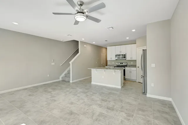 a view of kitchen with stainless steel appliances refrigerator stove microwave and cabinets