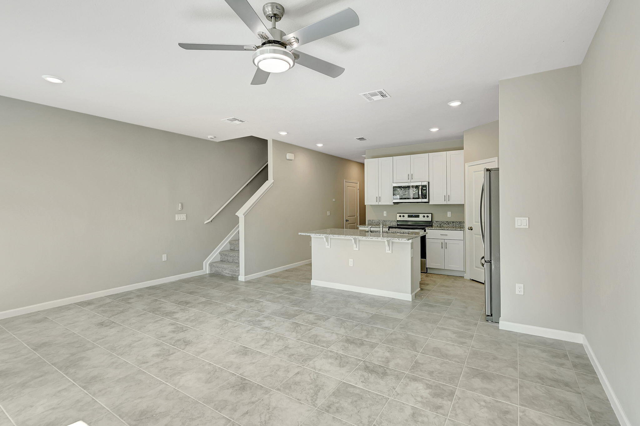 5694 Southeast Edgewater Circle Stuart, FL 34997 - Photo 8 of 22 a view of kitchen with stainless steel appliances refrigerator stove microwave and cabinets