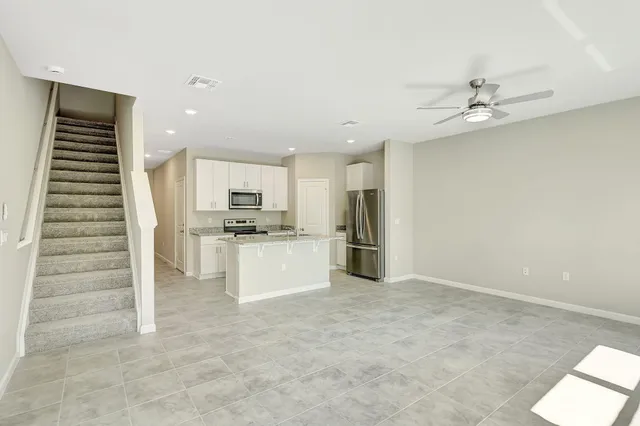 an open kitchen with white cabinets and stainless steel appliances
