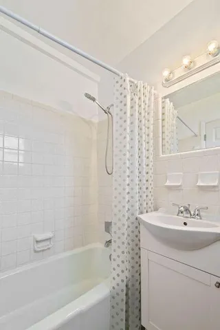 a bathroom with a sink a mirror a shower and a bathtub