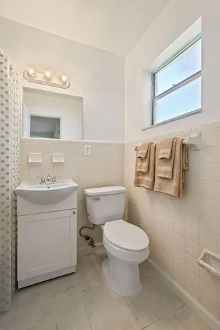 a bathroom with a toilet sink and mirror
