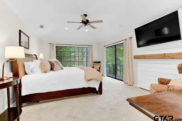 a bed room with a bed a flat screen tv and a couch