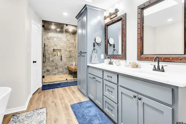 a spacious bathroom with a shower sink and mirror