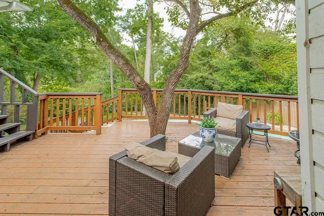 a view of deck with chairs and wooden fence