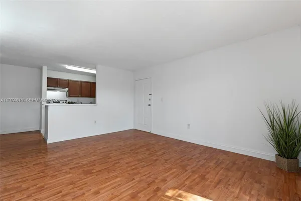 wooden floor in an empty room with a kitchen
