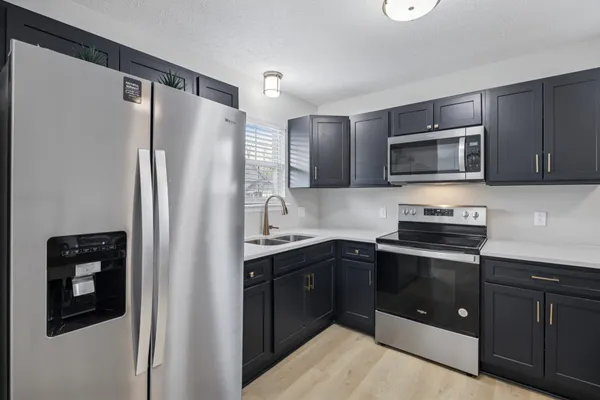 a kitchen with stainless steel appliances granite countertop a refrigerator and a stove top oven