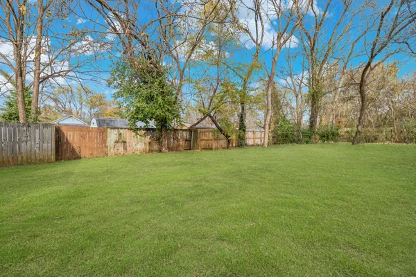 a view of a backyard with wooden fence
